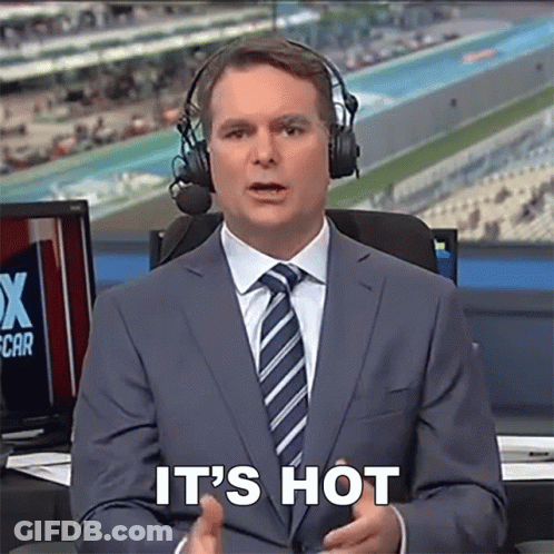 A Man In A Suit And Tie With Headphones Says It 'S Hot GIF