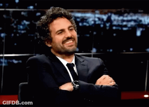 A Man In A Suit And Tie With His Arms Crossed GIF