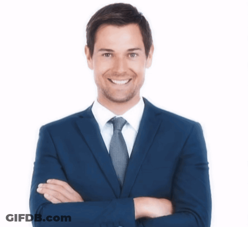 A Man In A Suit And Tie With His Arms Crossed Is Smiling GIF
