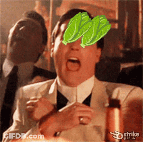 A Man In A Suit And Tie With Lettuce Leaves On His Face GIF