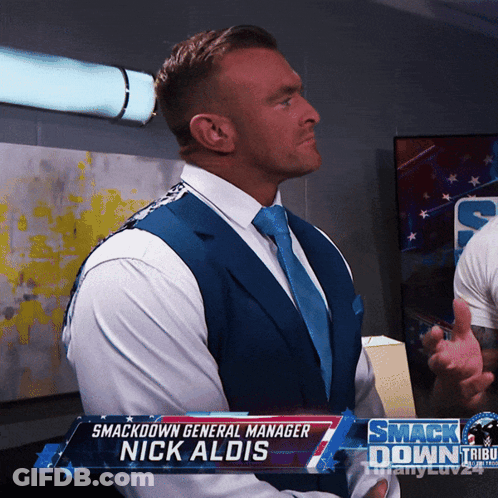 A Man In A Suit And Tie With The Name Nick Aldis GIF
