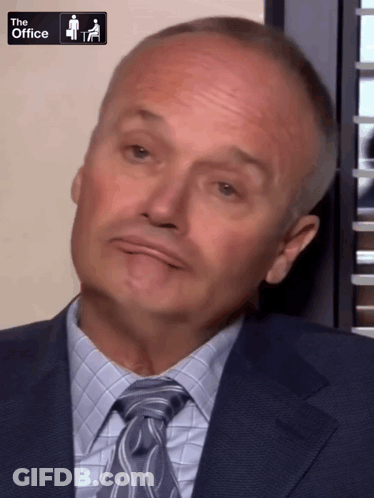 A Man In A Suit And Tie With The Office Logo On The Bottom GIF