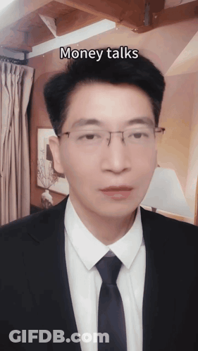 A Man In A Suit And Tie With The Words Money Talks Above His Head GIF