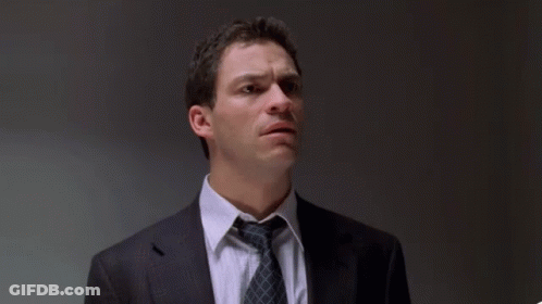 A Man In A Suit And Tie With The Words " The Fuck Did I Do " Behind Him GIF