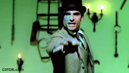 A Man In A Suit And Top Hat Is Pointing GIF