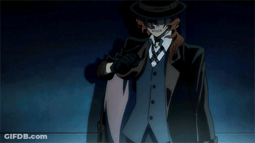 A Man In A Suit And Top Hat Is Standing In A Dark Room GIF