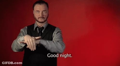 A Man In A Suit And Vest Is Making A Sign That Says Good Night GIF