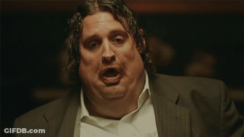 A Man In A Suit And White Shirt Has His Mouth Open GIF