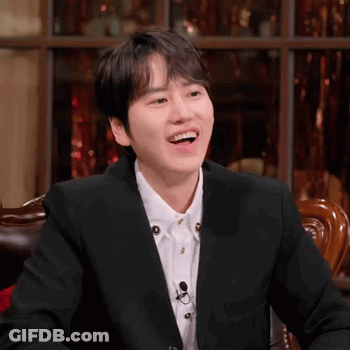 A Man In A Suit And White Shirt Is Laughing GIF