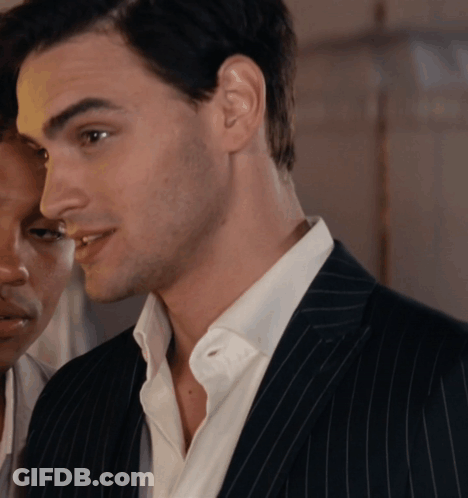 A Man In A Suit And White Shirt Is Looking At His Reflection In A Mirror GIF
