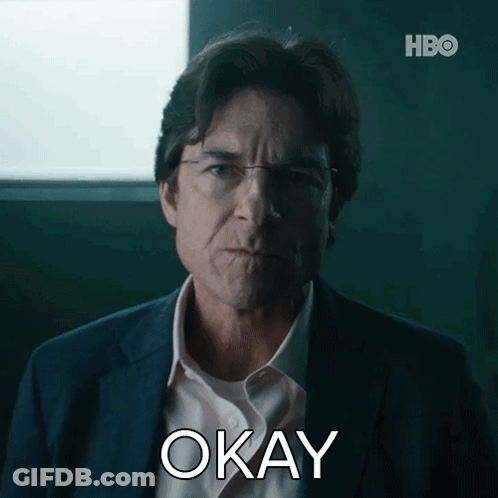 A Man In A Suit And White Shirt Is Making An Okay Gesture GIF