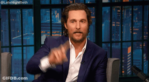A Man In A Suit And White Shirt Is Sitting In Front Of A Microphone With The Words Late Night Seth Written Above Him GIF