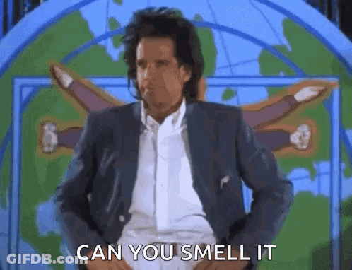 A Man In A Suit And White Shirt Is Standing In Front Of A Map . GIF