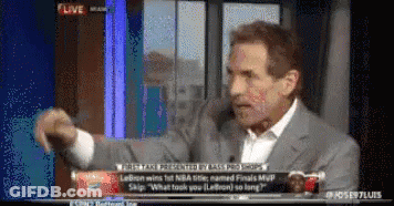 A Man In A Suit And White Shirt Is Talking On A Tv Screen GIF
