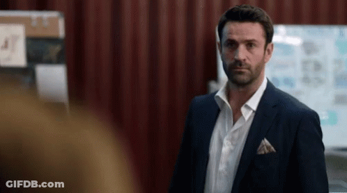A Man In A Suit And White Shirt Stands In Front Of A White Board With The Number 47 On It GIF