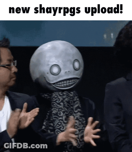 A Man In A Suit Applauds Next To A Man With A Mask On His Head That Says " New Shayrpgs Upload " GIF