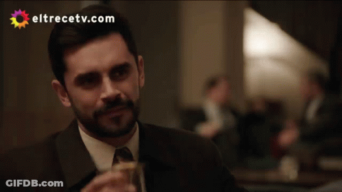 A Man In A Suit Drinking From A Glass With Eltrecetv.com Written On The Bottom GIF