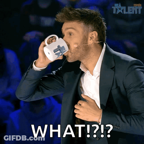 A Man In A Suit Drinking From A Mug With The Words What Written On The Bottom GIF