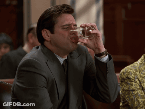 A Man In A Suit Drinks From A Glass GIF