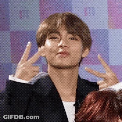 A Man In A Suit Giving A Peace Sign GIF