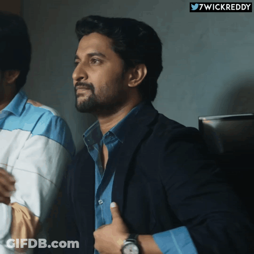 A Man In A Suit Giving A Thumbs Up Next To A Twitter Logo That Says 7Wickreddy GIF