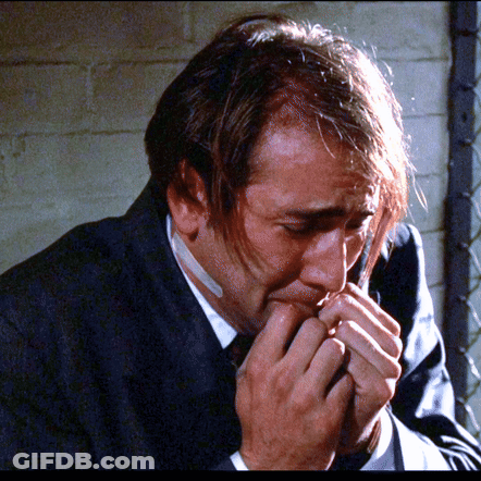 A Man In A Suit Has A Bandage On His Mouth GIF