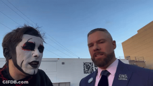 A Man In A Suit Has A Pin On His Jacket That Says ' J.s. ' On It GIF