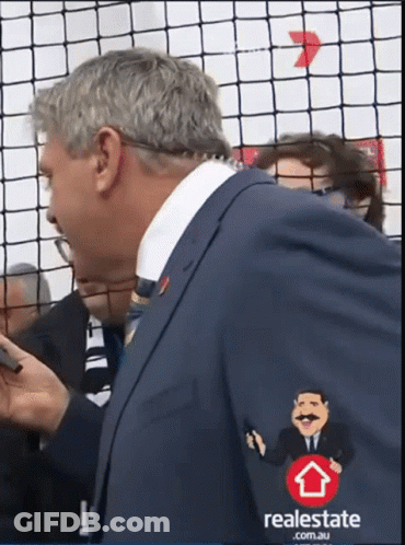 A Man In A Suit Has A Real Estate Logo On His Jacket GIF