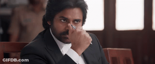 A Man In A Suit Holds A Pen In His Hand GIF