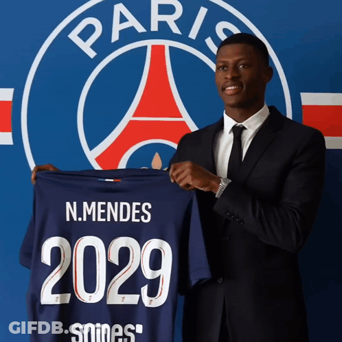 A Man In A Suit Holds Up A Shirt That Says 2029 GIF
