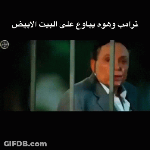 Man In Suit Behind Bars With Arabic Writing GIF