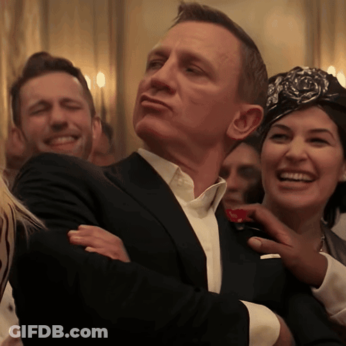 A Man In A Suit Is Being Touched By A Woman In A Headband GIF