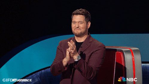 A Man In A Suit Is Clapping In Front Of A Nbc Sign GIF