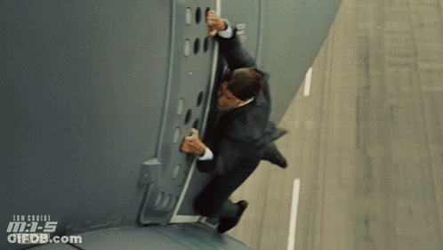 A Man In A Suit Is Climbing Up A Wall In A Scene From The Movie Mission Impossible Rogue Nation GIF