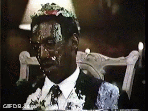 A Man In A Suit Is Covered In Cake GIF