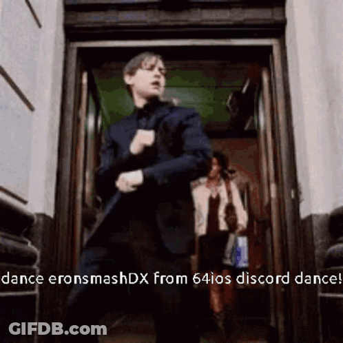 A Man In A Suit Is Dancing In A Doorway With The Words Dance Eronsmashdx From 64Ios Discord Dance GIF