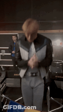 A Man In A Suit Is Dancing In Front Of A Box That Says Guest GIF