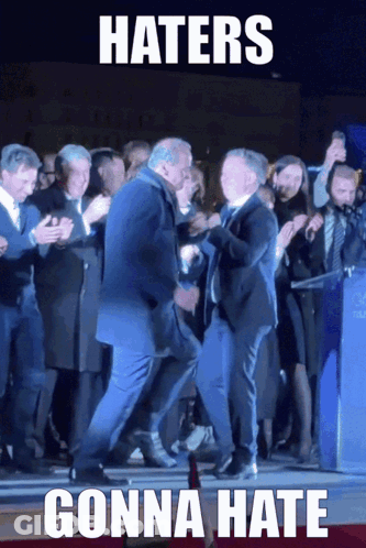 A Man In A Suit Is Dancing In Front Of A Crowd With A Caption That Says Haters Gonna Hate GIF
