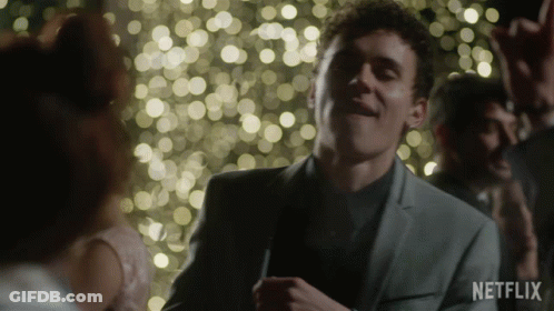 A Man In A Suit Is Dancing In Front Of A Crowd With A Netflix Logo In The Corner GIF