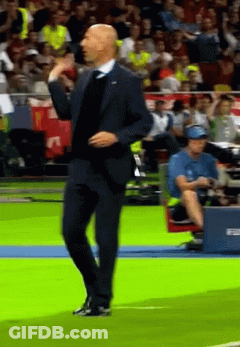 A Man In A Suit Is Dancing On A Field GIF