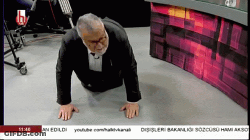 A Man In A Suit Is Doing Push Ups On The Floor In Front Of A Youtube Channel GIF