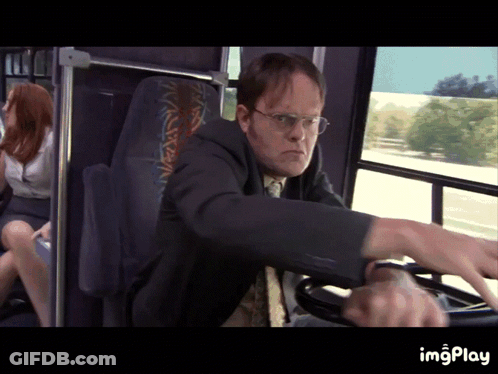 A Man In A Suit Is Driving A Bus With A Woman Sitting In The Back Seat GIF