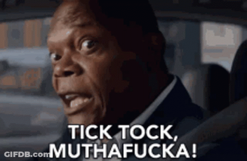 A Man In A Suit Is Driving A Car And Saying Tick Tock , Muthafucka ! GIF
