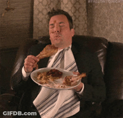 A Man In A Suit Is Eating A Plate Of Food GIF