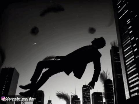 A Man In A Suit Is Falling Through The Air In A City GIF
