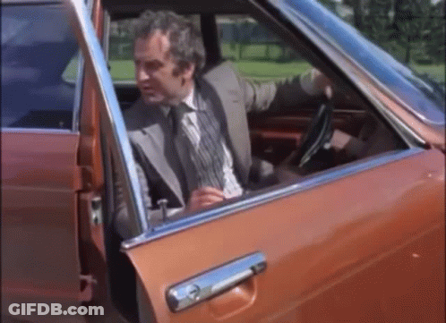A Man In A Suit Is Getting Out Of A Car GIF