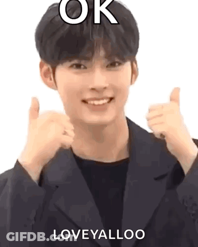 A Man In A Suit Is Giving A Thumbs Up Sign . GIF