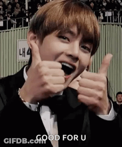 A Man In A Suit Is Giving Two Thumbs Up . GIF