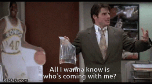 A Man In A Suit Is Holding A Bag And Says All I Wanna Know Is Who 'S Coming GIF