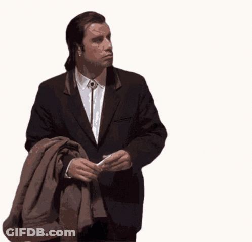 A Man In A Suit Is Holding A Brown Jacket GIF